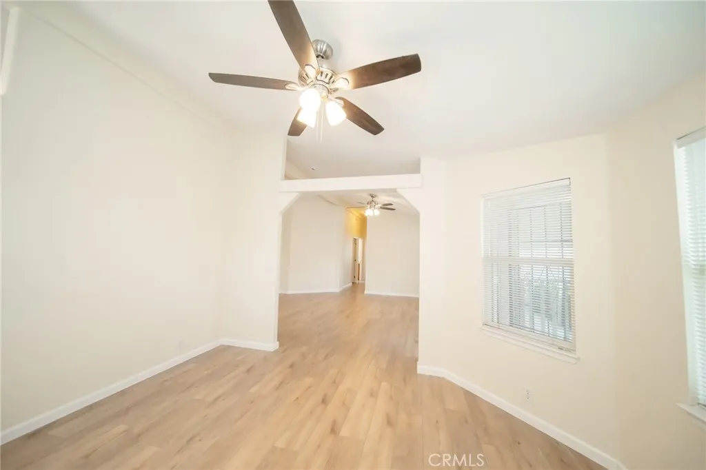 49 Pine Via Anaheim, CA 92802 - Photo 15 of 23 a view of an empty room with wooden floor and a ceiling fan