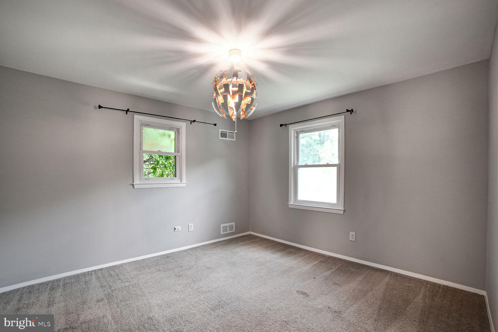 716 Downs Drive Silver Spring, MD 20904 - Photo 19 of 33 an empty room with windows and a chandelier