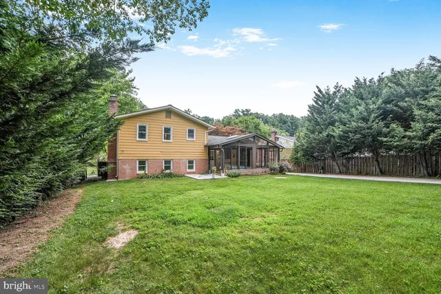 a view of a big house with a big yard and large trees