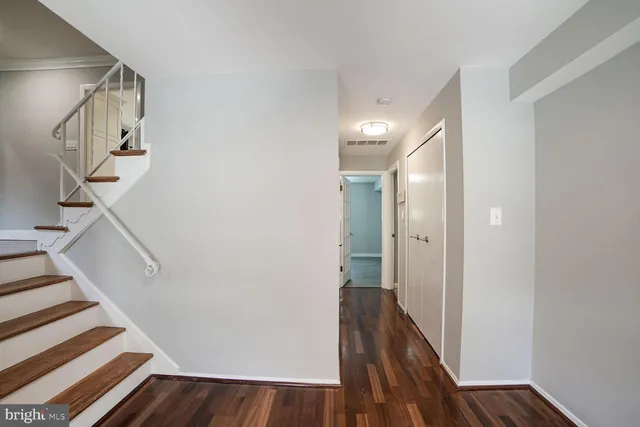a view of a hallway with wooden floor and staircase
