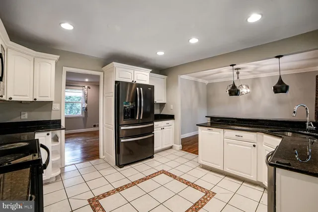a kitchen with granite countertop a refrigerator and a stove top oven