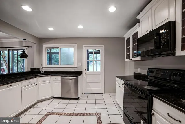 a kitchen with stainless steel appliances a stove sink microwave and cabinets