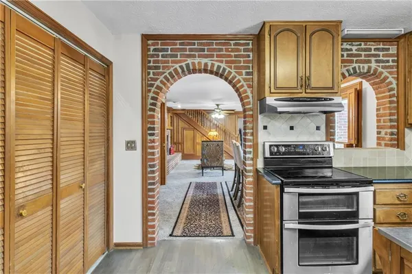 a kitchen with stainless steel appliances granite countertop a stove and a wooden cabinets