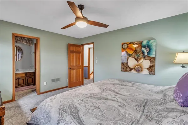 a bedroom with a large bed and a painting on the wall