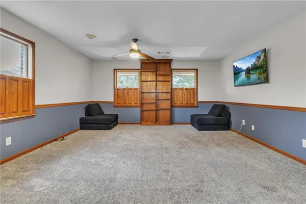 an empty room with windows and cabinet