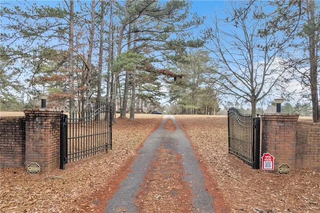 a living room with a bed a chandelier and a large window