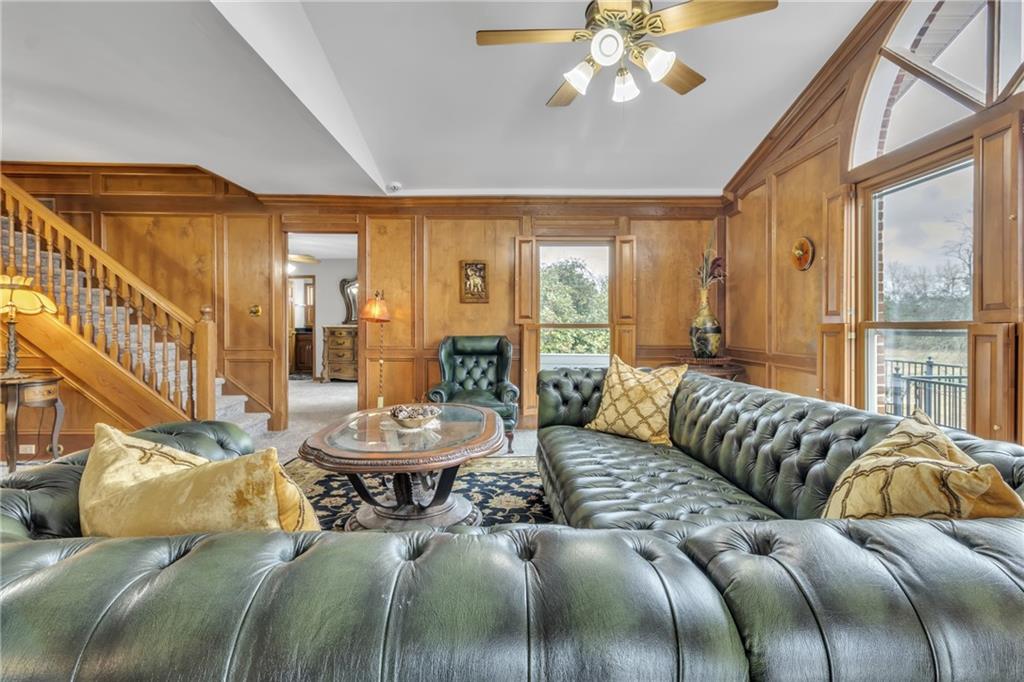 838 Conyers Road McDonough, GA 30252 - Photo 9 of 31 a living room with a bed a chandelier and a large window