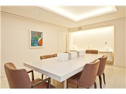 Dining room photo with a white table and beige chairs. 