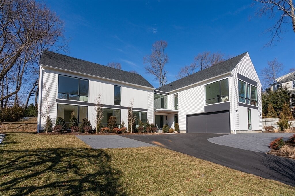 White house with paved driveway and large windows