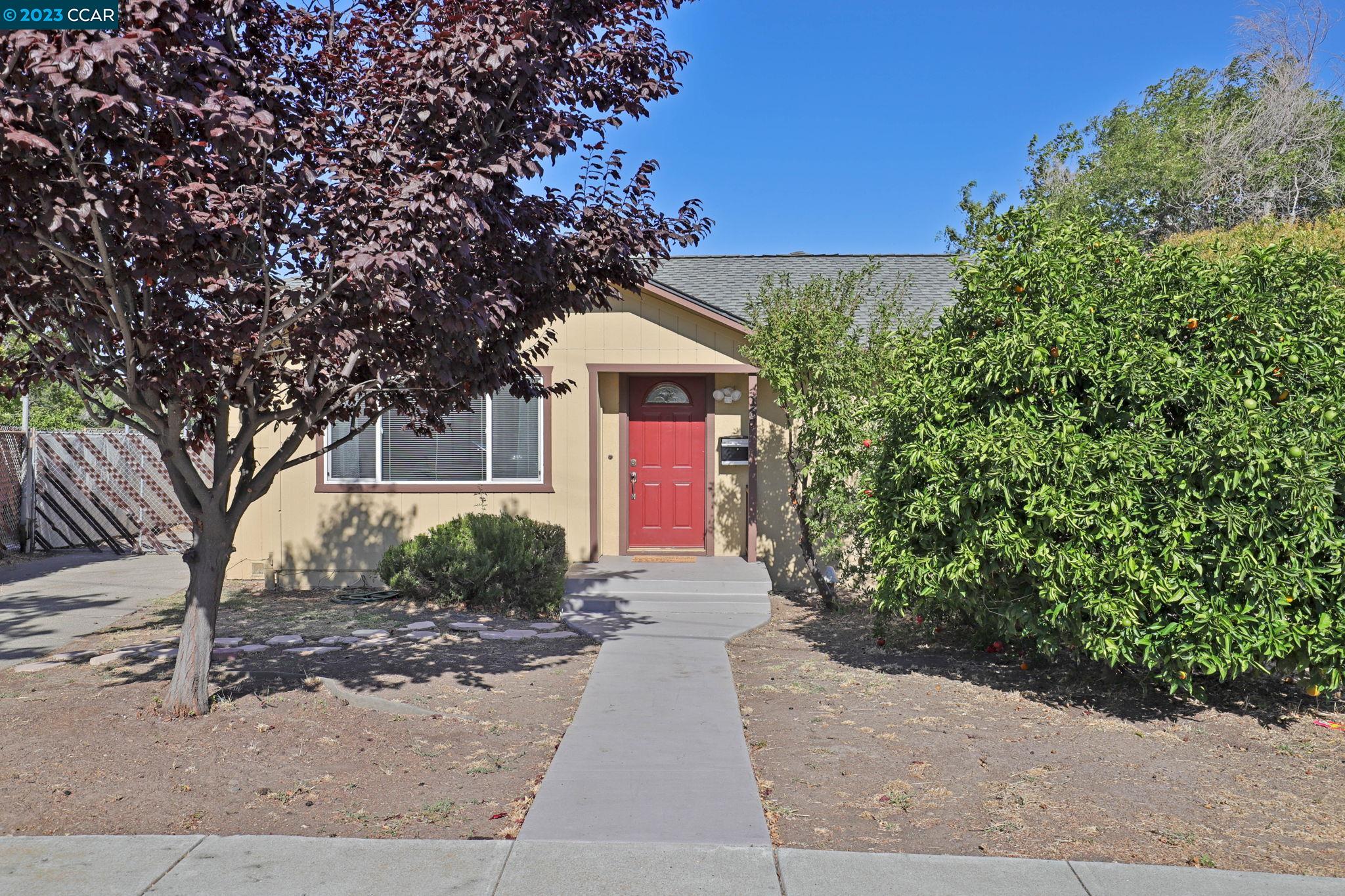 a front view of a house with a yard and trees