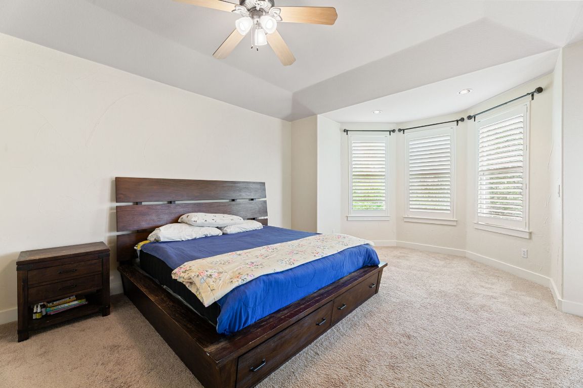 2800 Waymaker Way, Unit 63 Austin, TX 78746 - Photo 21 of 36 a bedroom with a bed and a chandelier