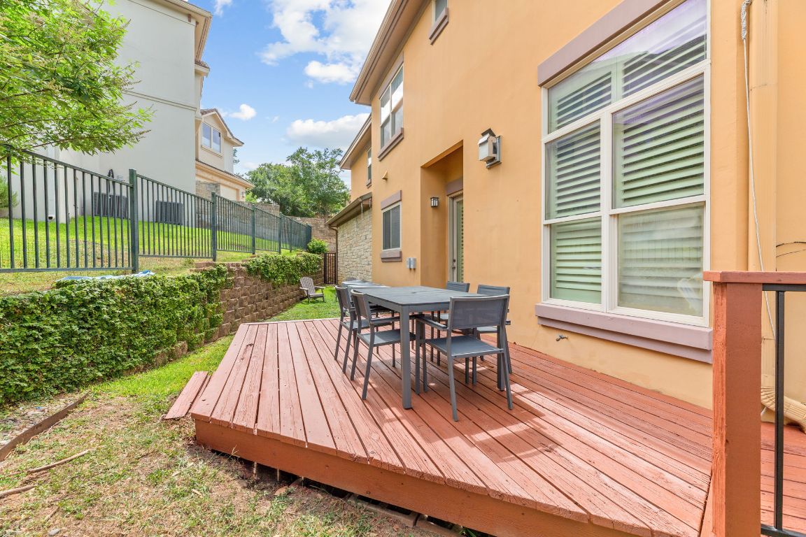 2800 Waymaker Way, Unit 63 Austin, TX 78746 - Photo 23 of 36 a view of a deck with table and chairs with wooden floor and fence
