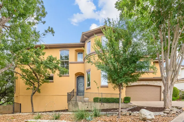 a front view of a house with a tree