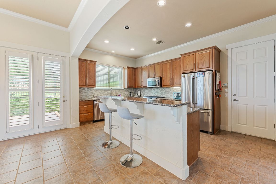 2800 Waymaker Way, Unit 63 Austin, TX 78746 - Photo 7 of 36 a kitchen with a refrigerator a sink and cabinets