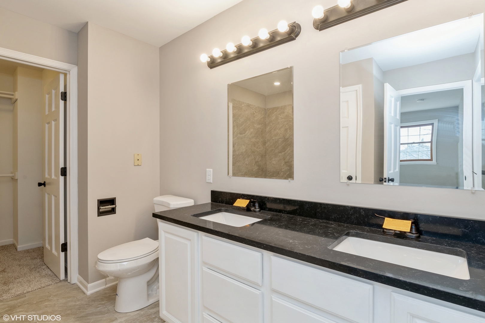 4818 5th Street Winthrop Harbor, IL 60096 - Photo 12 of 17 a bathroom with a granite countertop sink a toilet a mirror and shower