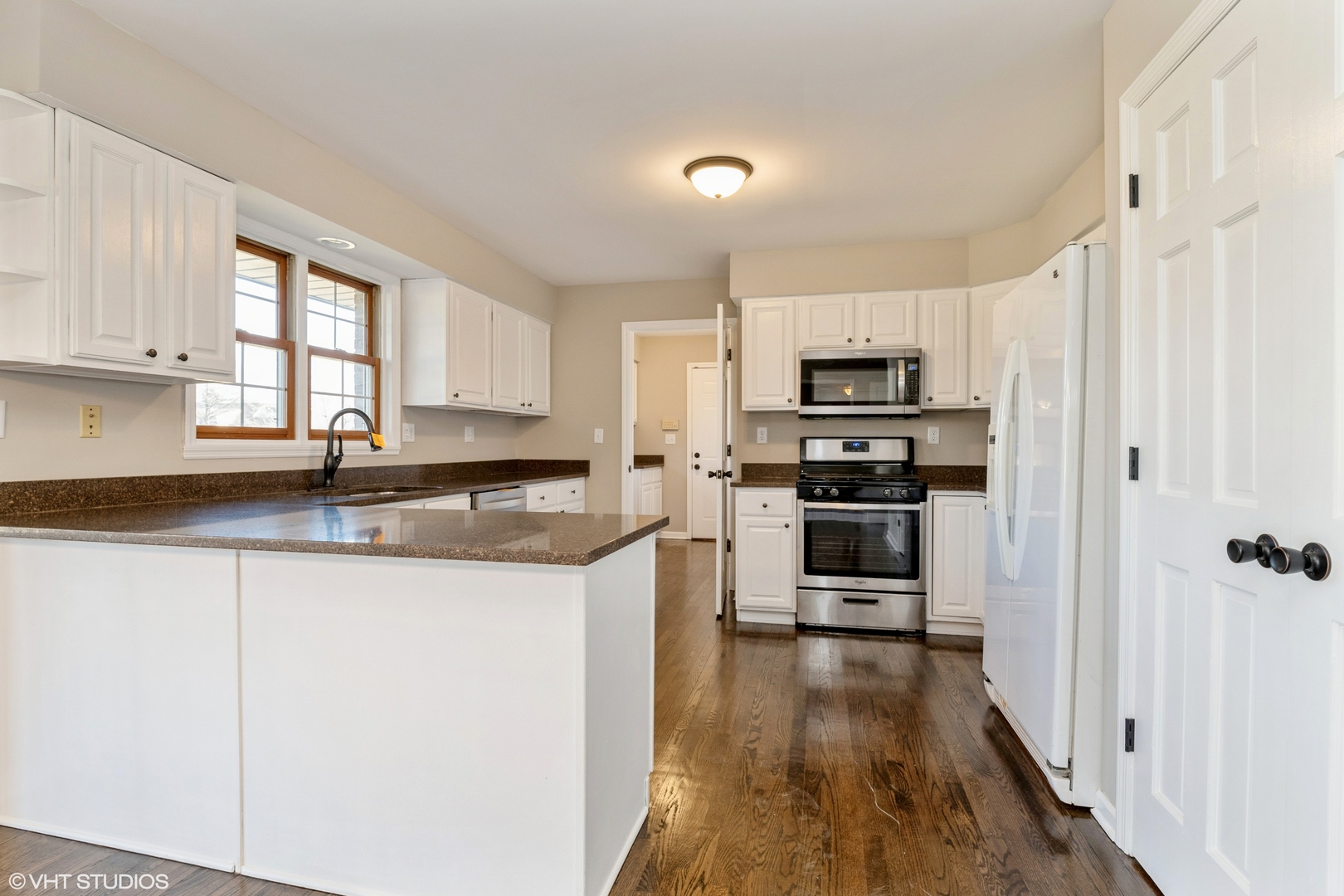 4818 5th Street Winthrop Harbor, IL 60096 - Photo 9 of 17 a kitchen with granite countertop a refrigerator a sink a stove top oven and a dishwasher next to a window