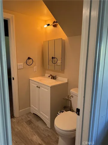 a bathroom with a toilet a sink a mirror and vanity