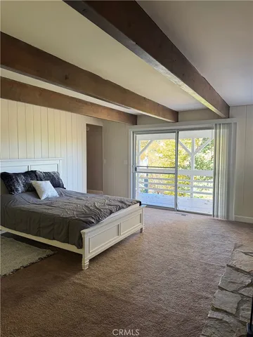 a bed sitting in a spacious bedroom next to a window