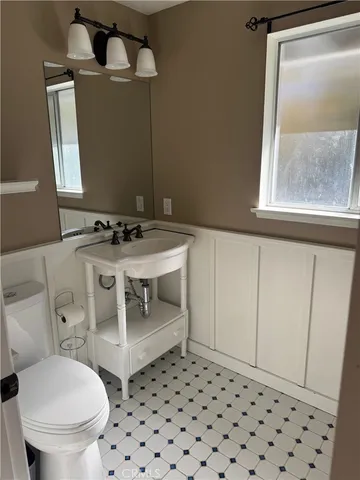 a bathroom with a sink toilet and window