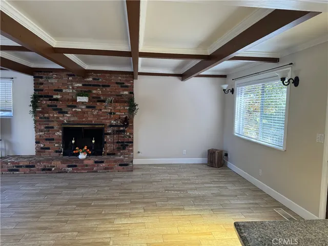 a view of empty room with wooden floor and fireplace