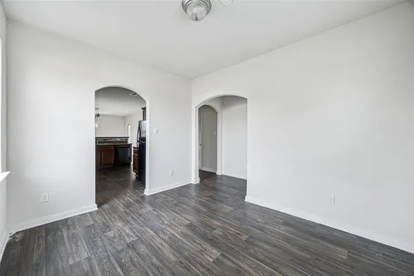 an empty room with wooden floor and a window