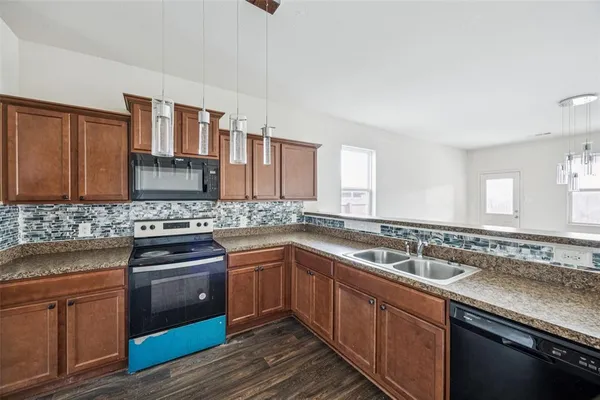 a kitchen with stainless steel appliances granite countertop a sink stove cabinets and wooden floor