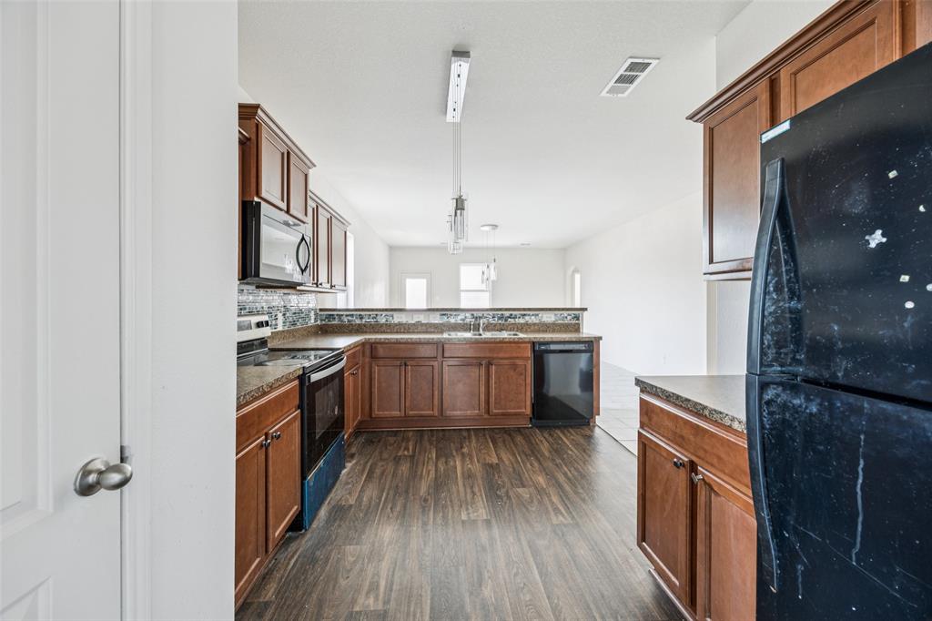 1020 Walnut Ridge Drive Hutchins, TX 75141 - Photo 9 of 28 a kitchen with stainless steel appliances kitchen island granite countertop a stove a sink and a refrigerator