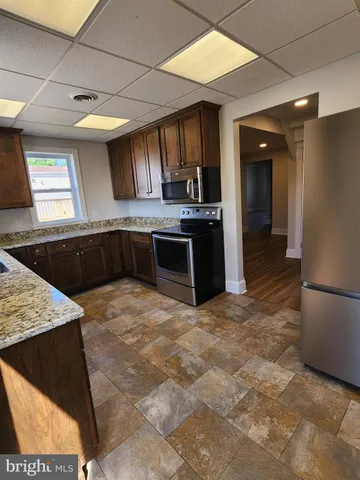 a large kitchen with kitchen island a sink stove and refrigerator