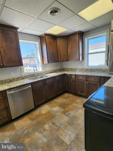 a large kitchen with granite countertop a sink and a stove