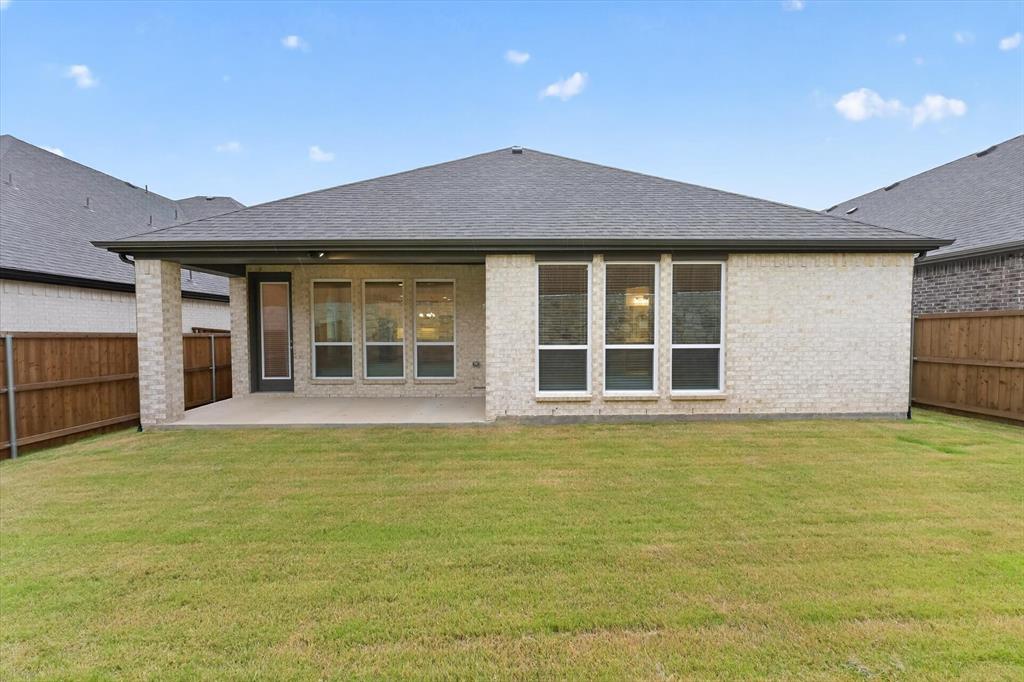 4123 Windy Point Court Oak Point, TX 75068 - Photo 4 of 29 Expansive backyard featuring a manicured lawn, full privacy fencing, light brick exterior, and a covered concrete patio
