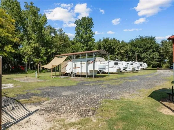a view of a house with a big yard and large trees