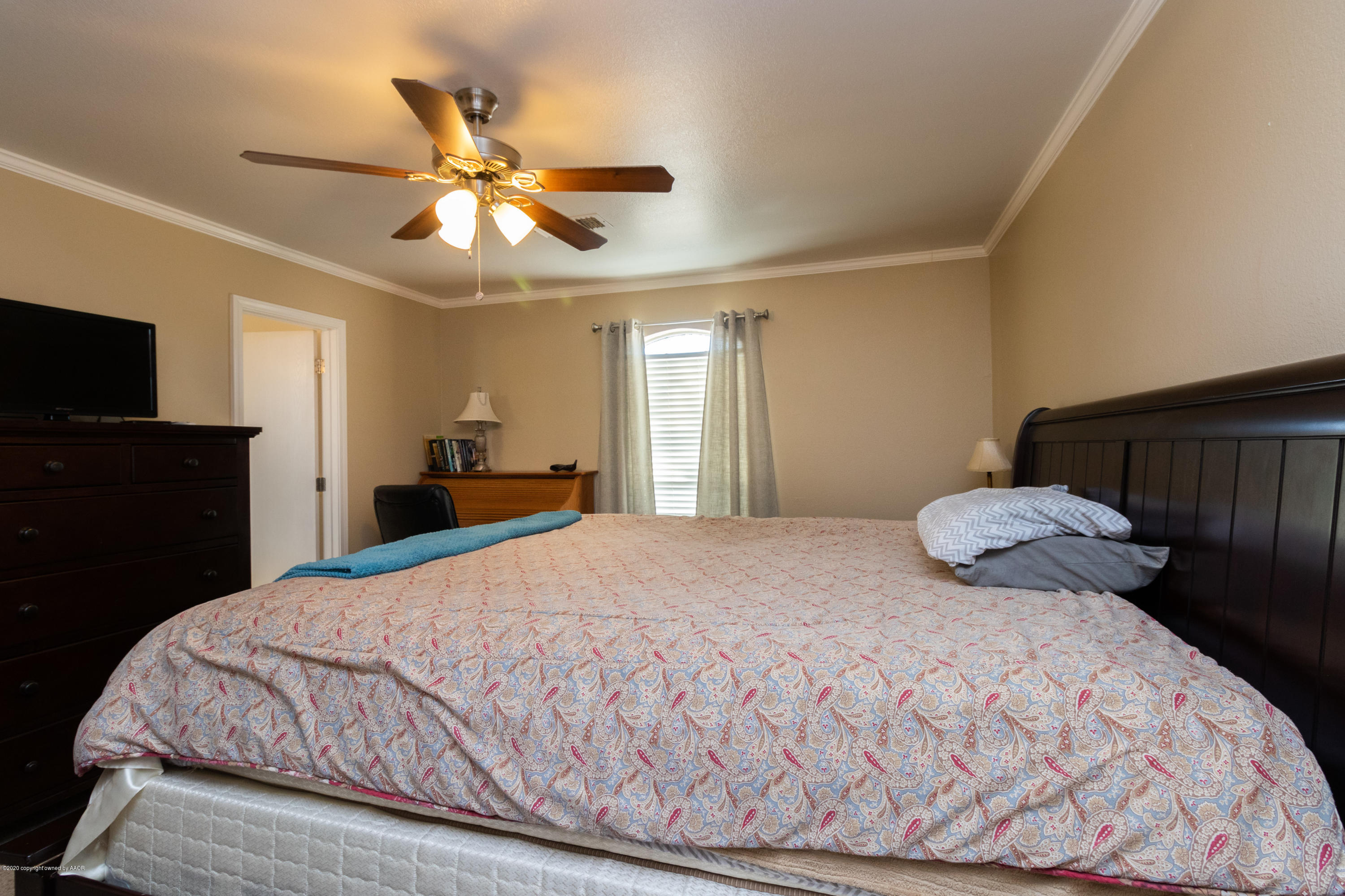 5203 Capulin Lane Amarillo, TX 79110 - Photo 15 of 29 a bedroom with a bed and a chandelier