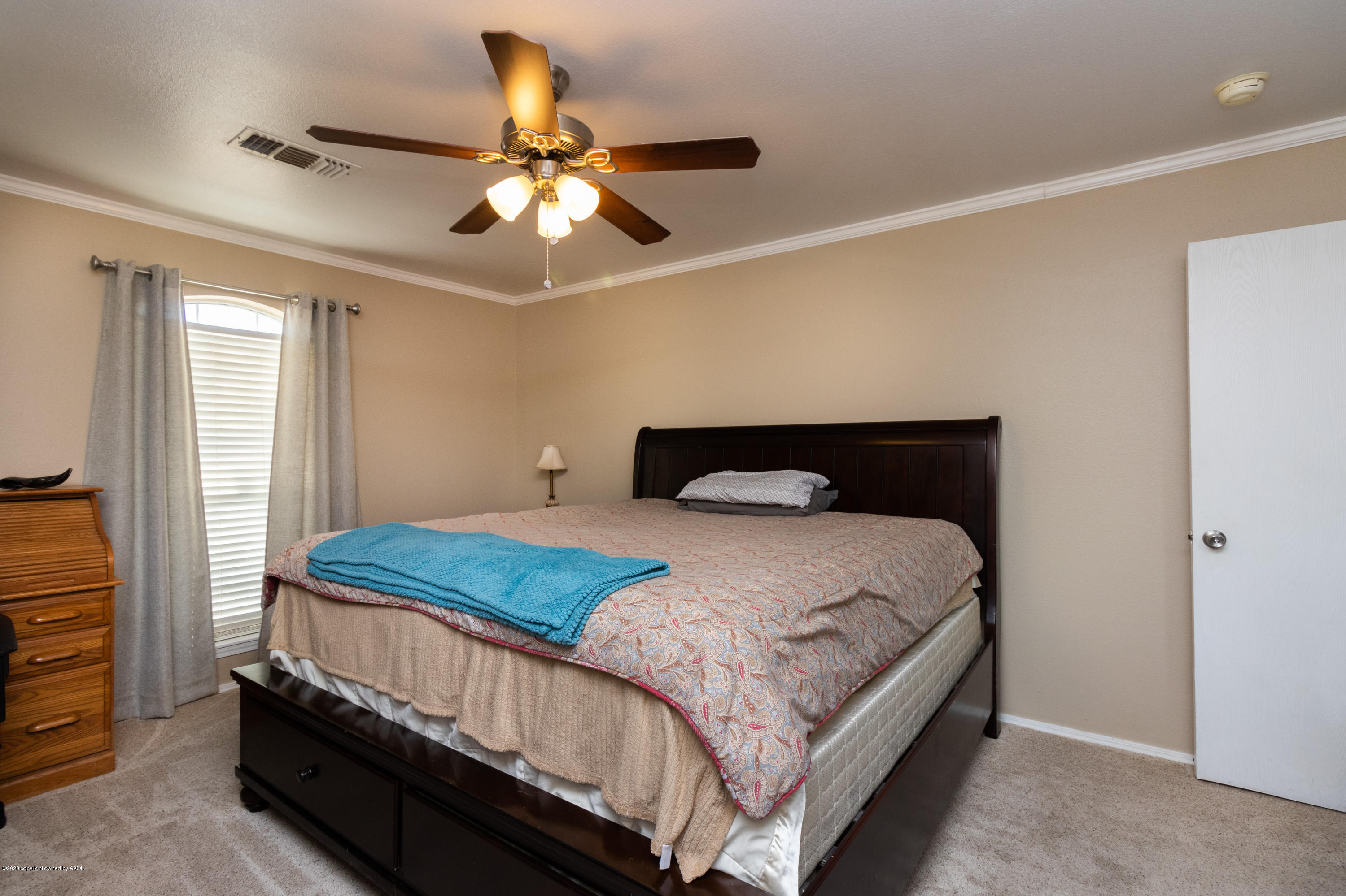 5203 Capulin Lane Amarillo, TX 79110 - Photo 16 of 29 a bedroom with a bed and a chandelier