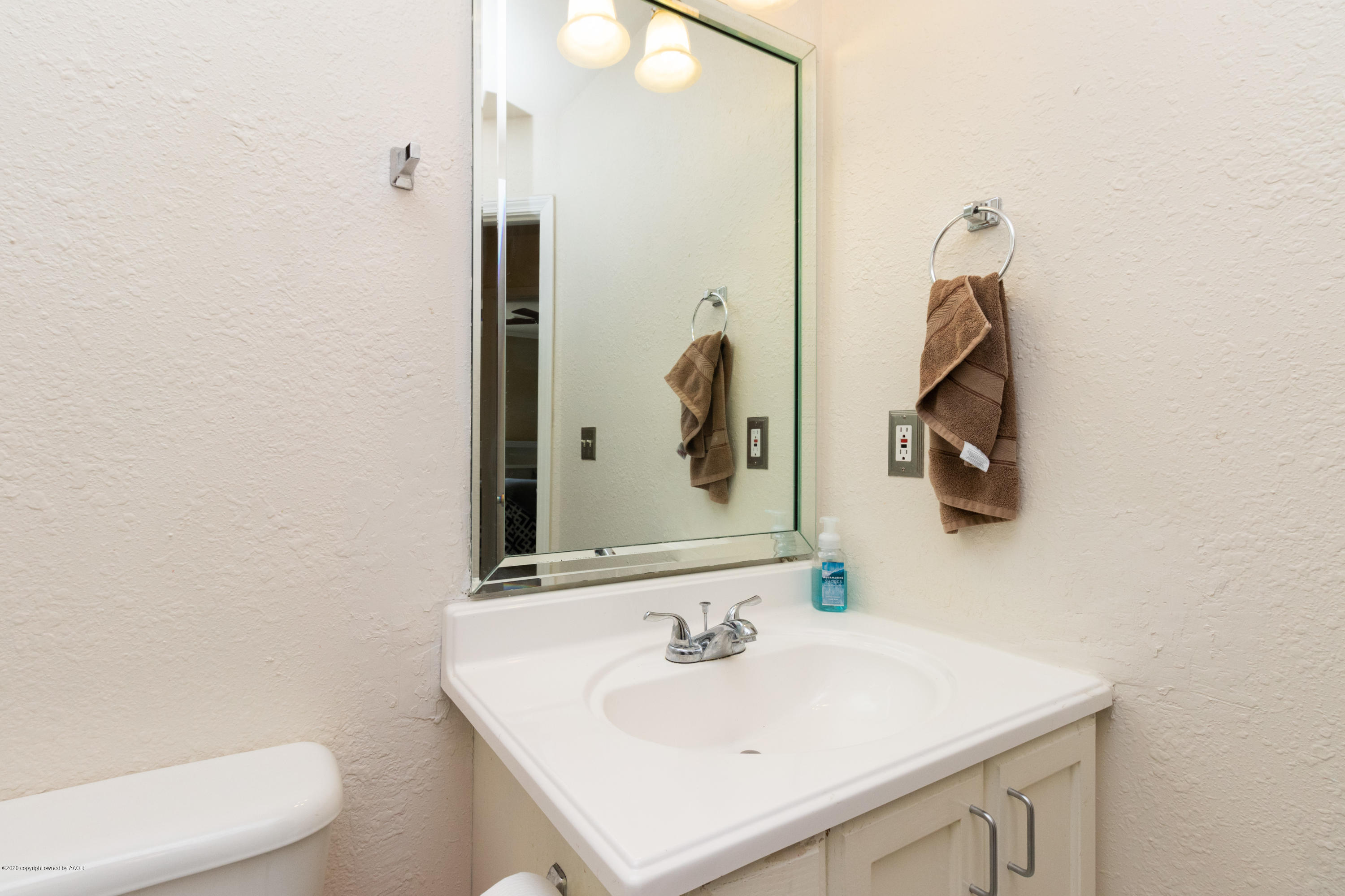 5203 Capulin Lane Amarillo, TX 79110 - Photo 21 of 29 a bathroom with a sink a toilet and mirror