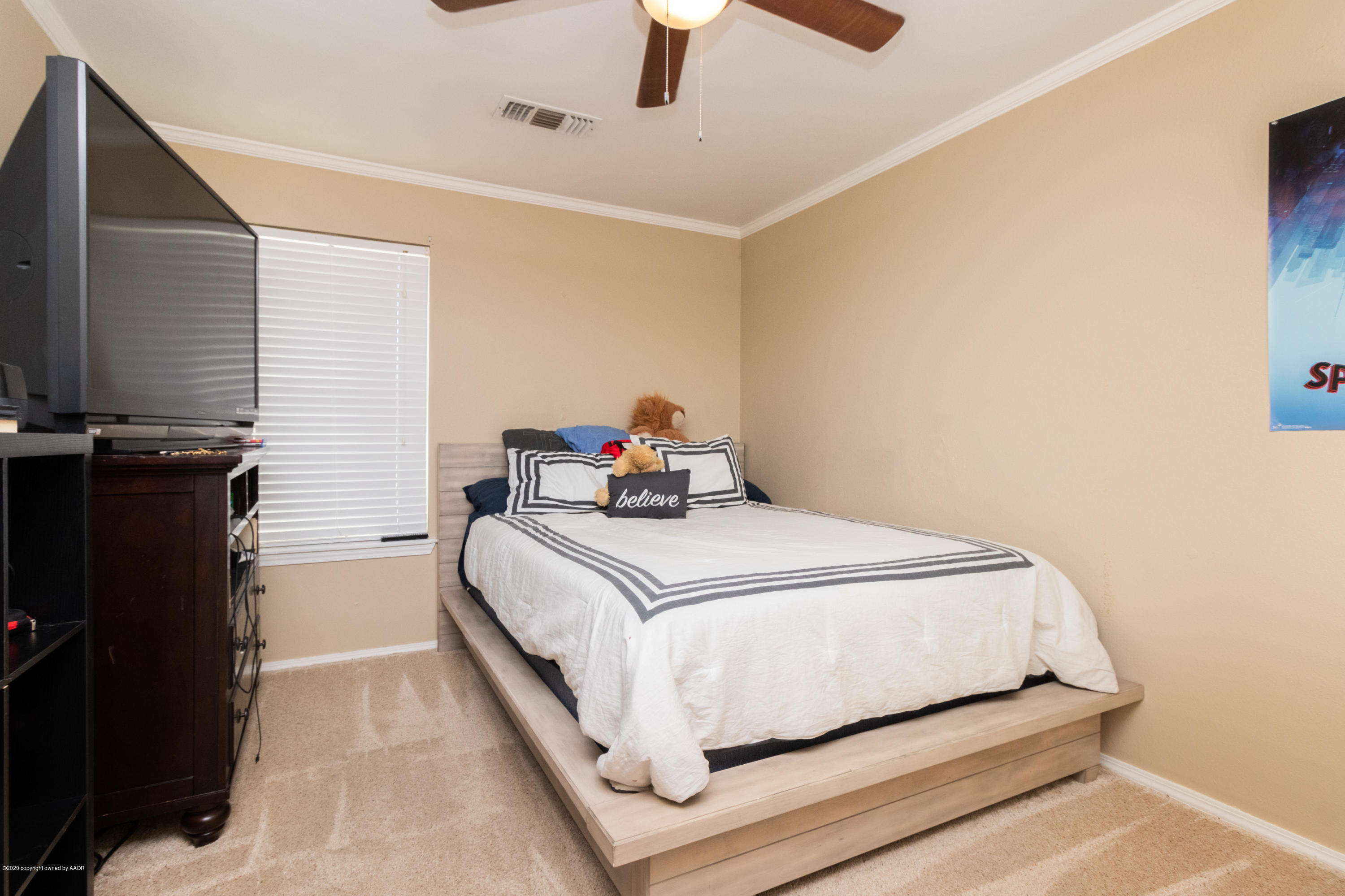 5203 Capulin Lane Amarillo, TX 79110 - Photo 23 of 29 a bedroom with a bed and a flat tv screen