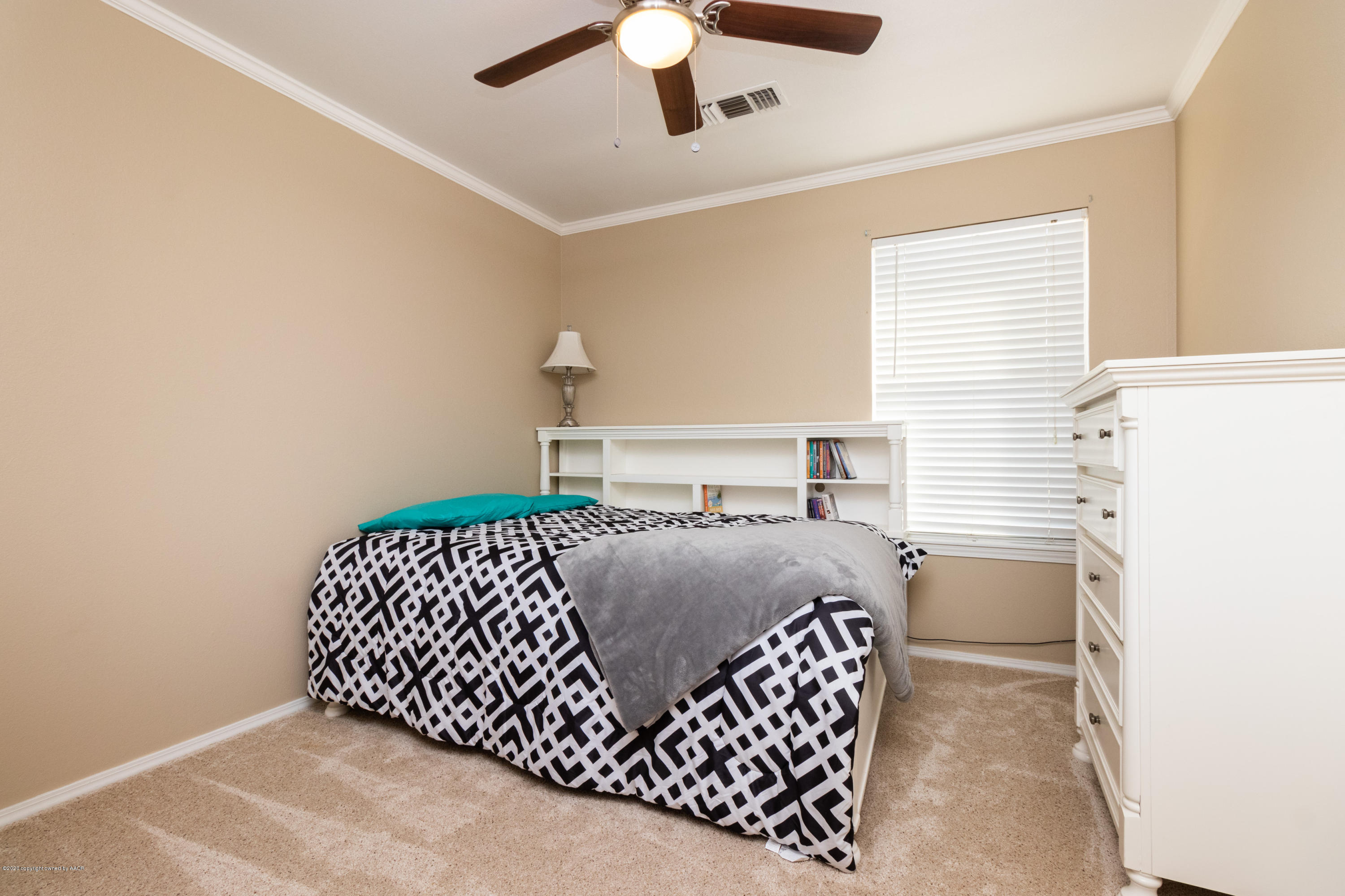 5203 Capulin Lane Amarillo, TX 79110 - Photo 25 of 29 a bedroom with a bed and a chandelier