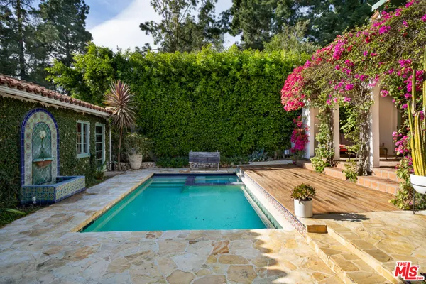 a front view of a house with a yard and potted plants
