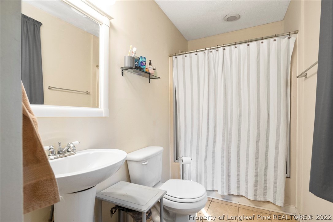 5011 Maxwell Road Autryville, NC 28318 - Photo 28 of 36 a white toilet sitting next to a bathroom sink