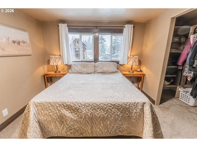 a bedroom with a bed and a flat tv screen on the dresser