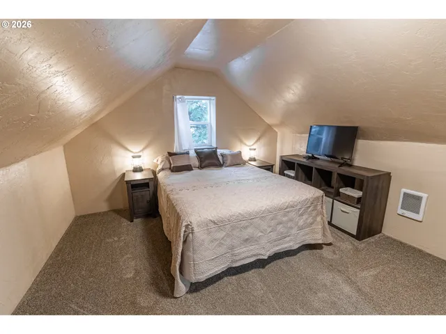 a bedroom with a bed and a view of kitchen