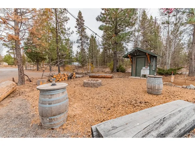 a backyard of a house with barbeque oven table and chairs