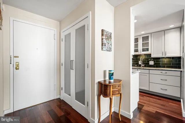 a kitchen with stainless steel appliances granite countertop a stove a sink and a refrigerator with wooden floors