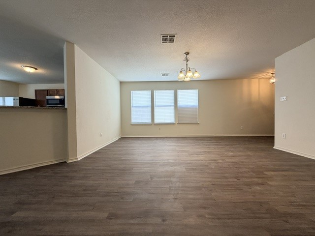 18421 Crestwind Lane Elgin, TX 78621 - Photo 9 of 34 Expansive wood-look flooring anchors this airy open-concept living space accented by triple windows.