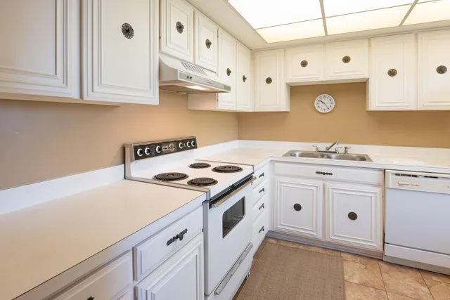 a kitchen with cabinets appliances a sink and a stove