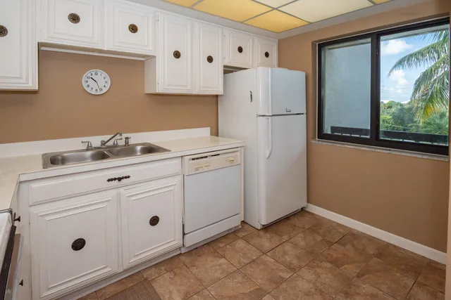 a kitchen with cabinets and a refrigerator