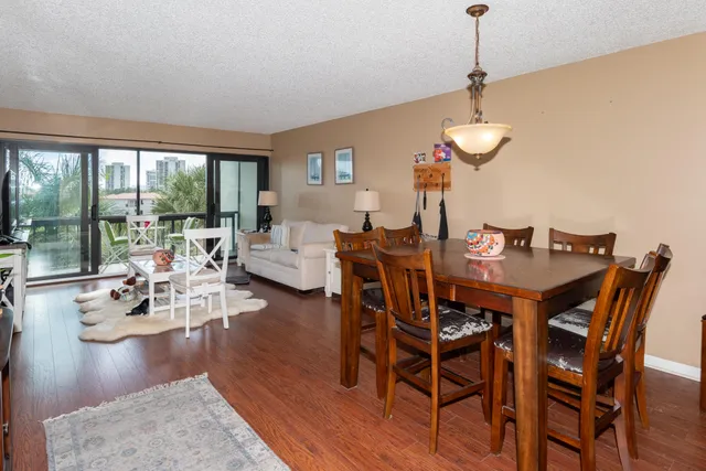 a view of a dining room and livingroom with furniture wooden floor a chandelier