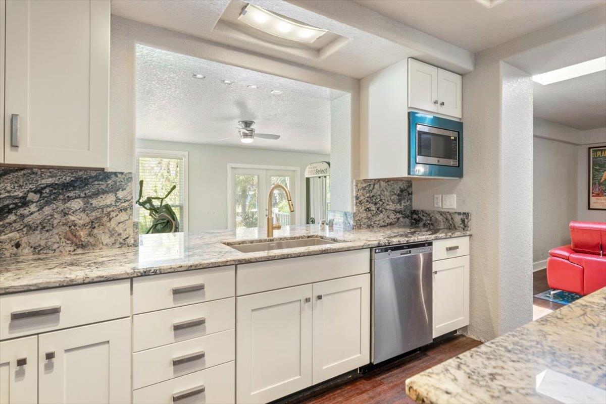 6342 Salado Road St. Augustine, FL 32080 - Photo 23 of 74 a kitchen with granite countertop white cabinets and white appliances