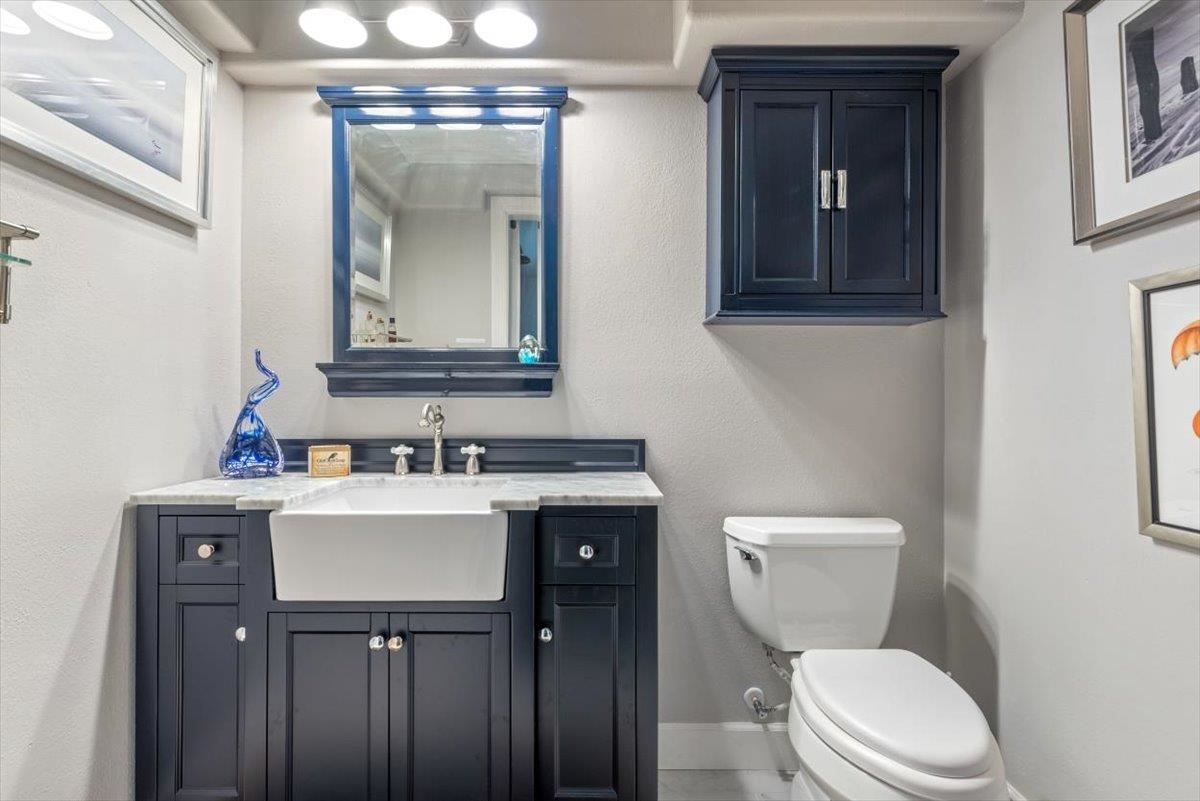 6342 Salado Road St. Augustine, FL 32080 - Photo 37 of 74 a bathroom with a toilet sink vanity and mirror