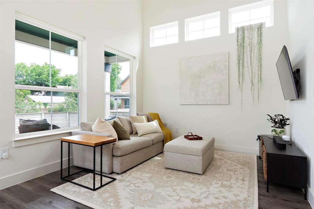 911 Stobaugh Street, Unit 2 Austin, TX 78757 - Photo 11 of 26 Spacious living area featuring high ceilings, ample natural light from multiple large windows, and dark wood-finish flooring
