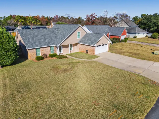 a view of house with a yard and potted plants